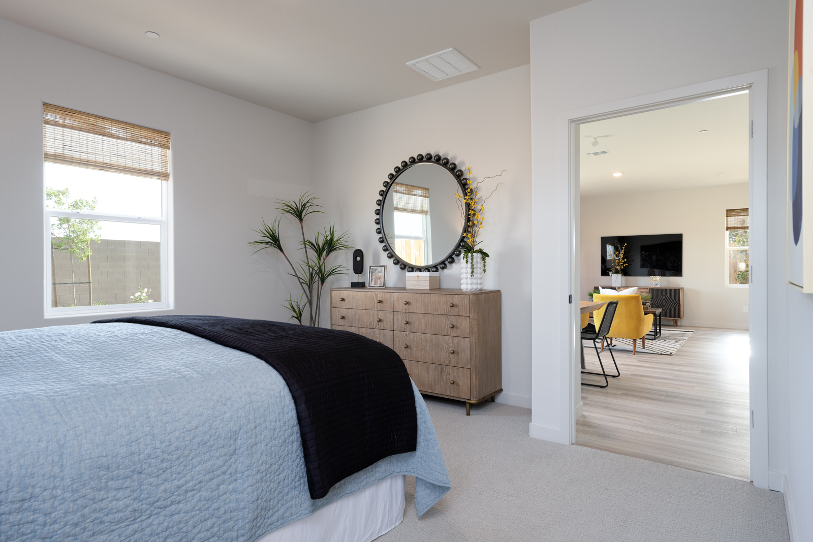 A bedroom with a bed and a mirror.