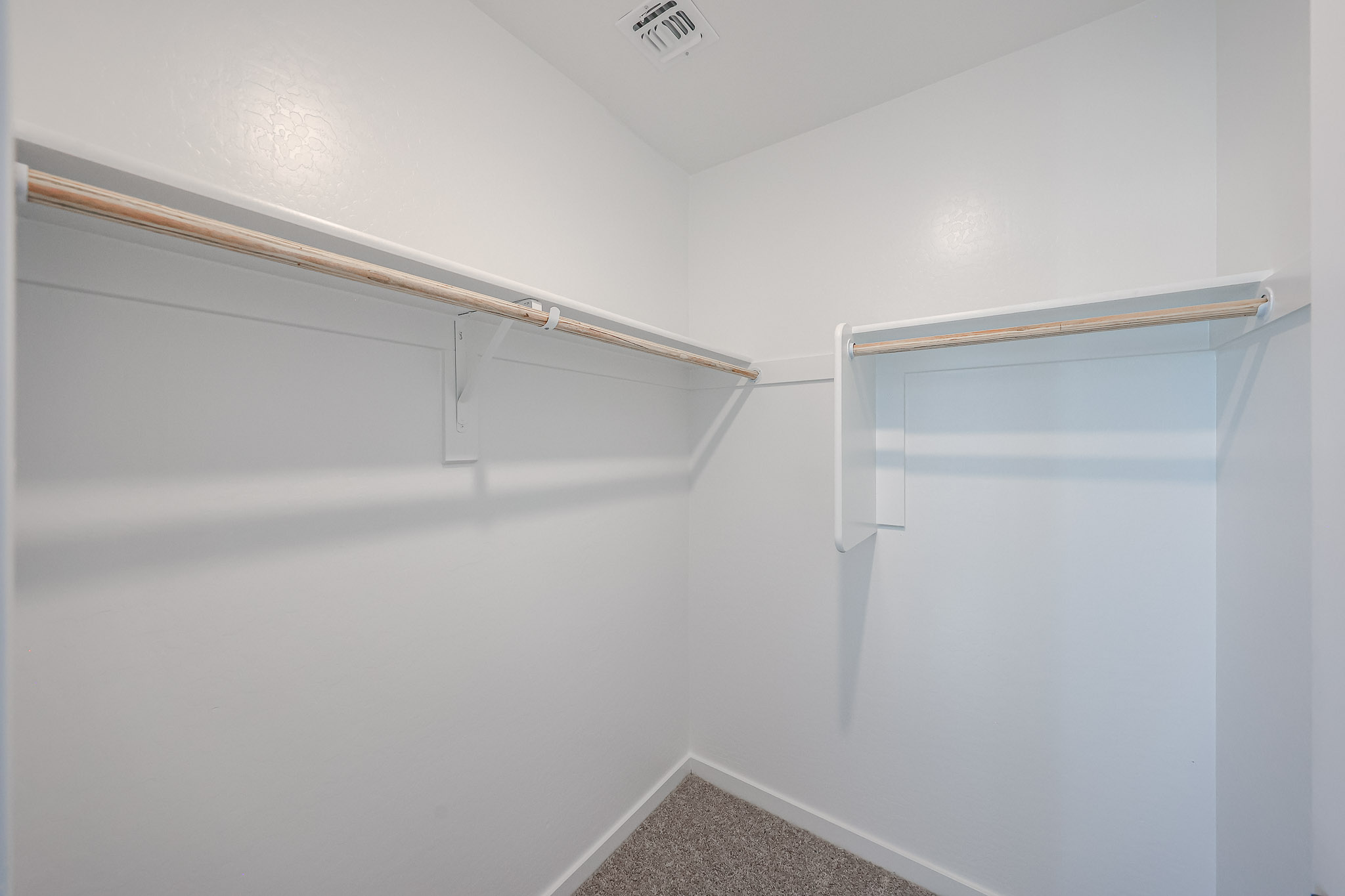 A white hallway with a metal railing.
