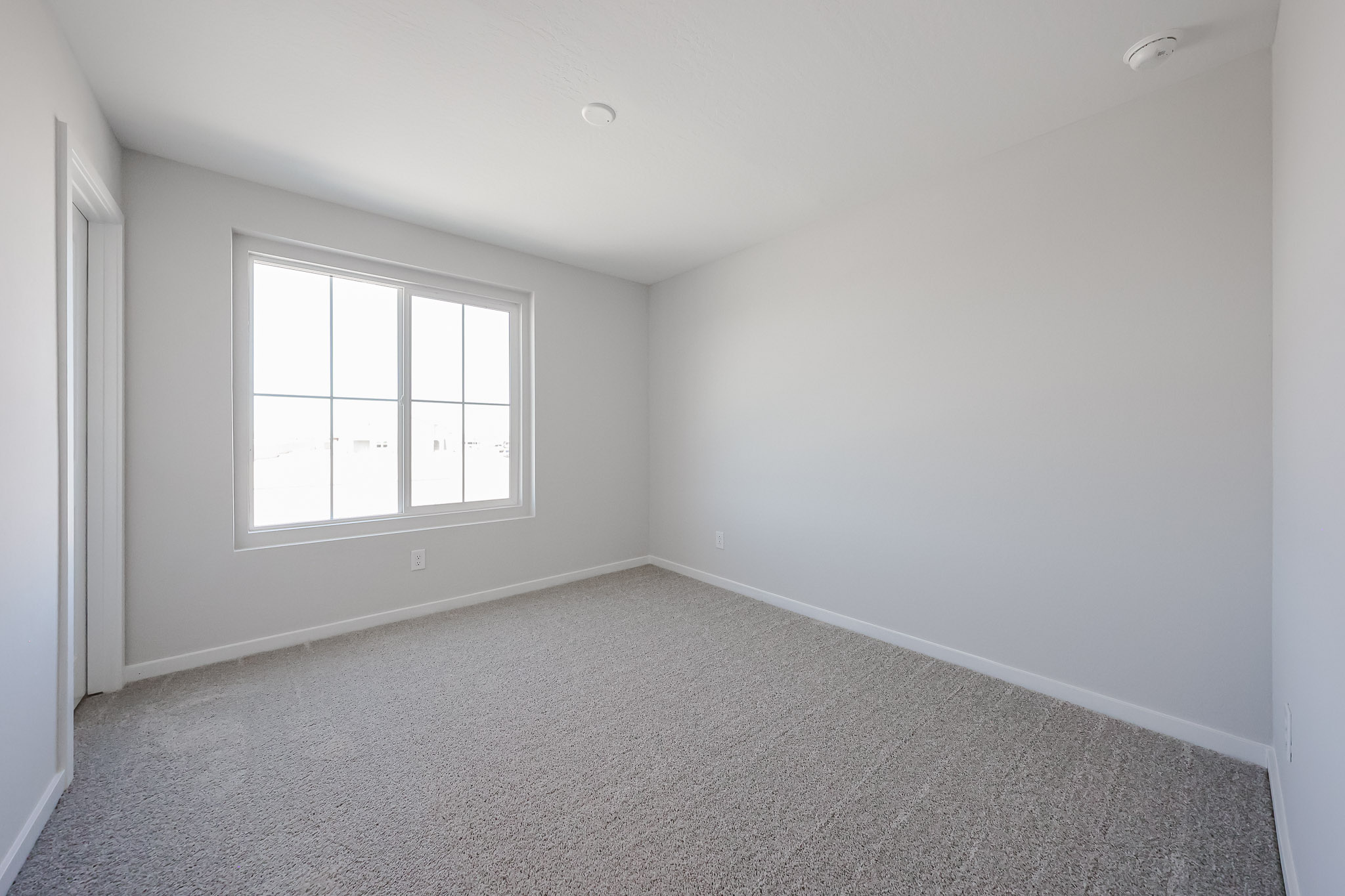 A room with a window and carpet.