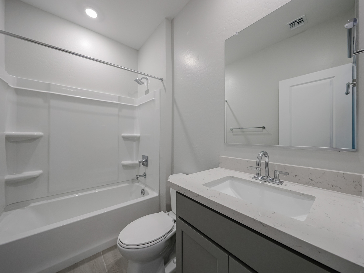 A bathroom with a tub sink and toilet.