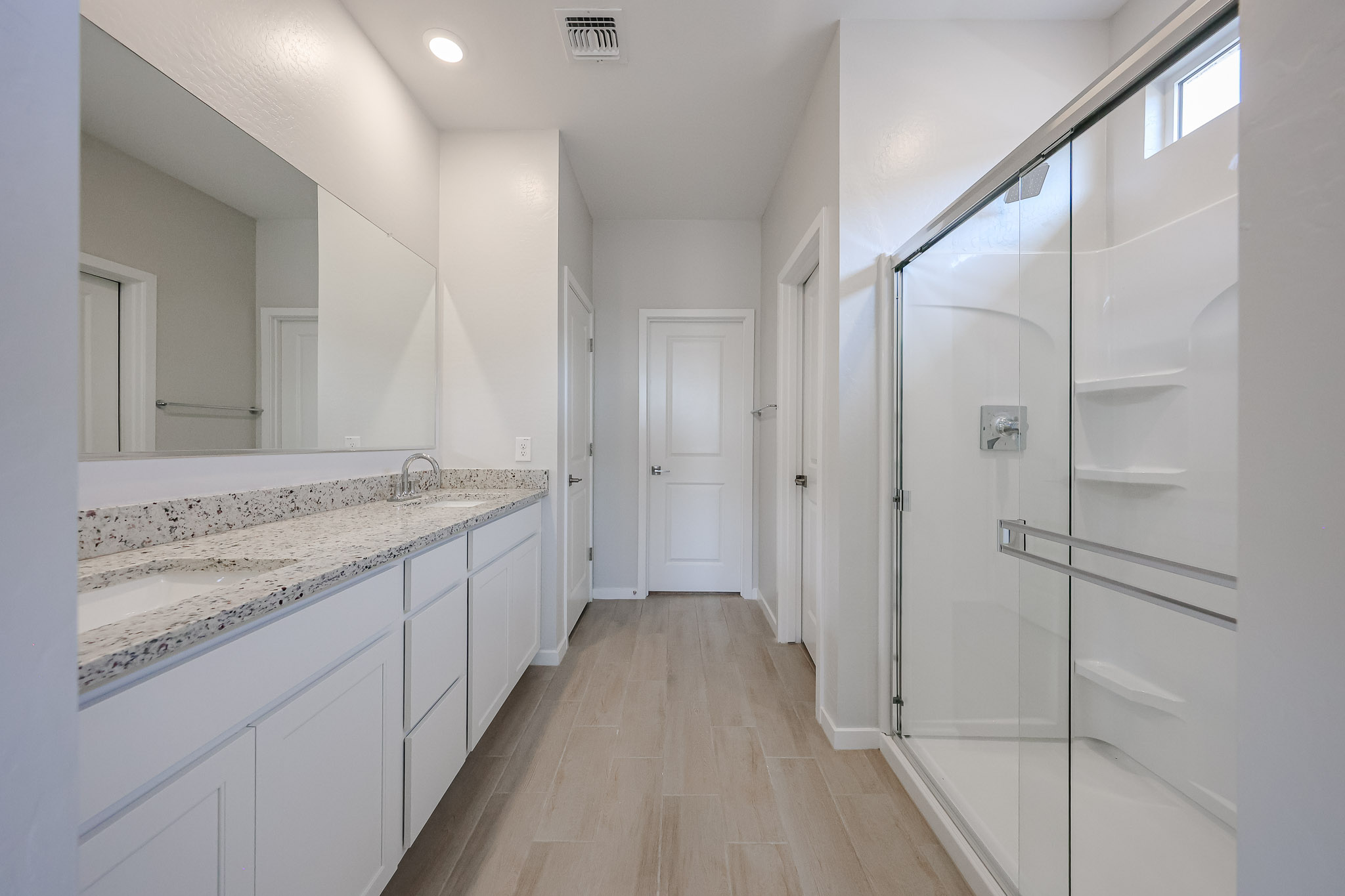 A bathroom with white cabinets.