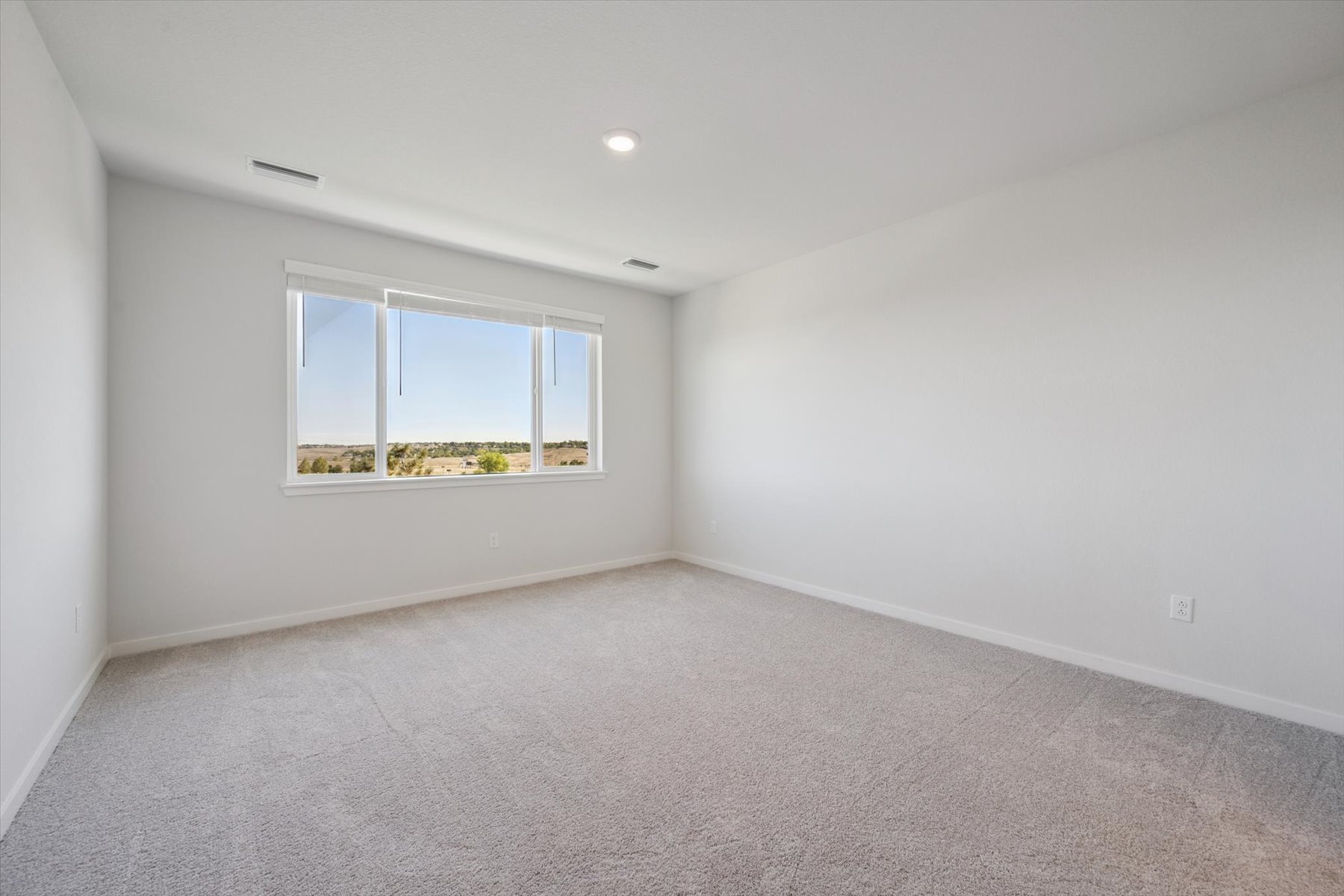 A room with a window and a carpet.