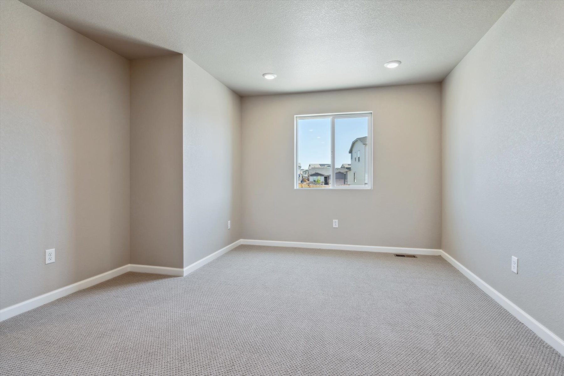 A room with a window and a carpet.