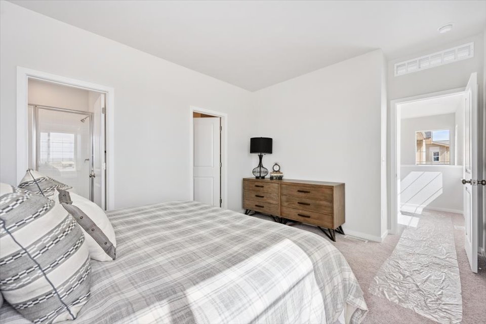 A bedroom with a bed and a dresser.