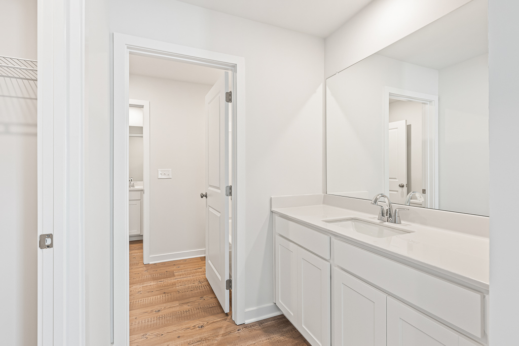 A bathroom with white cabinets.