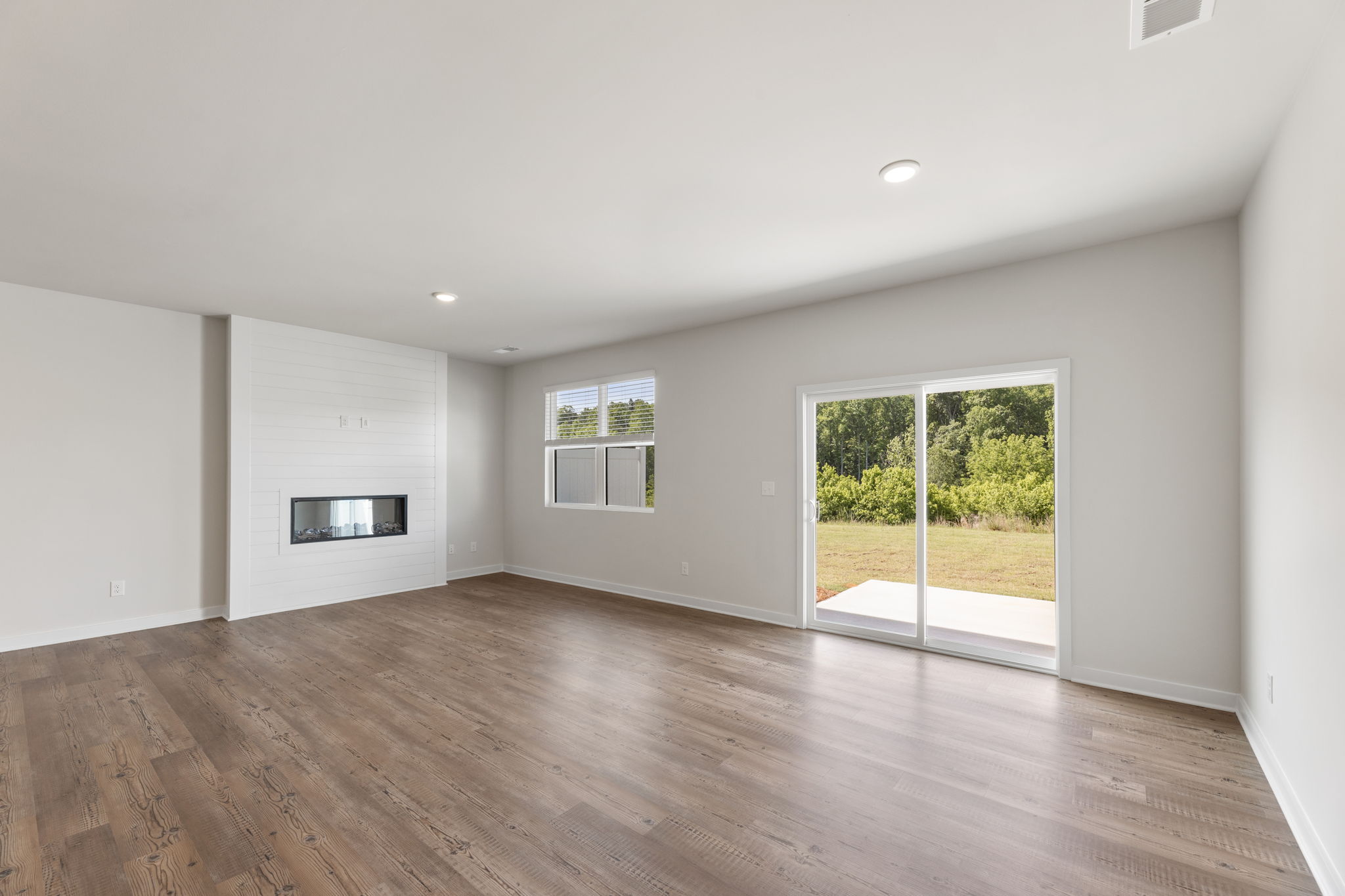 A room with a wood floor and a wood floor with a window.