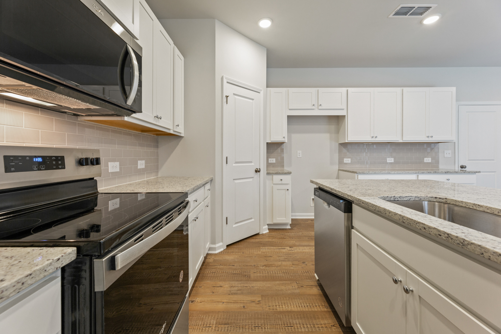 A kitchen with white cabinets.