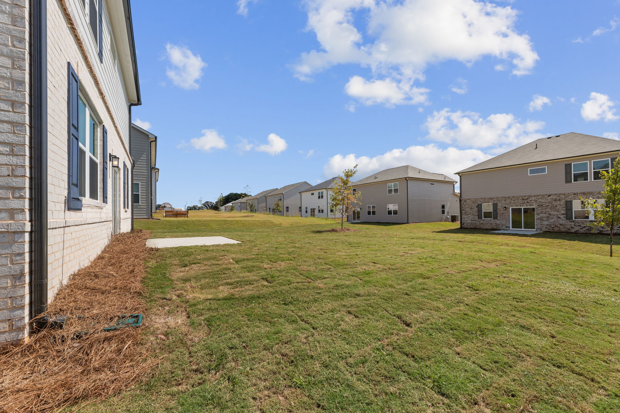 A grassy area with buildings in the background.