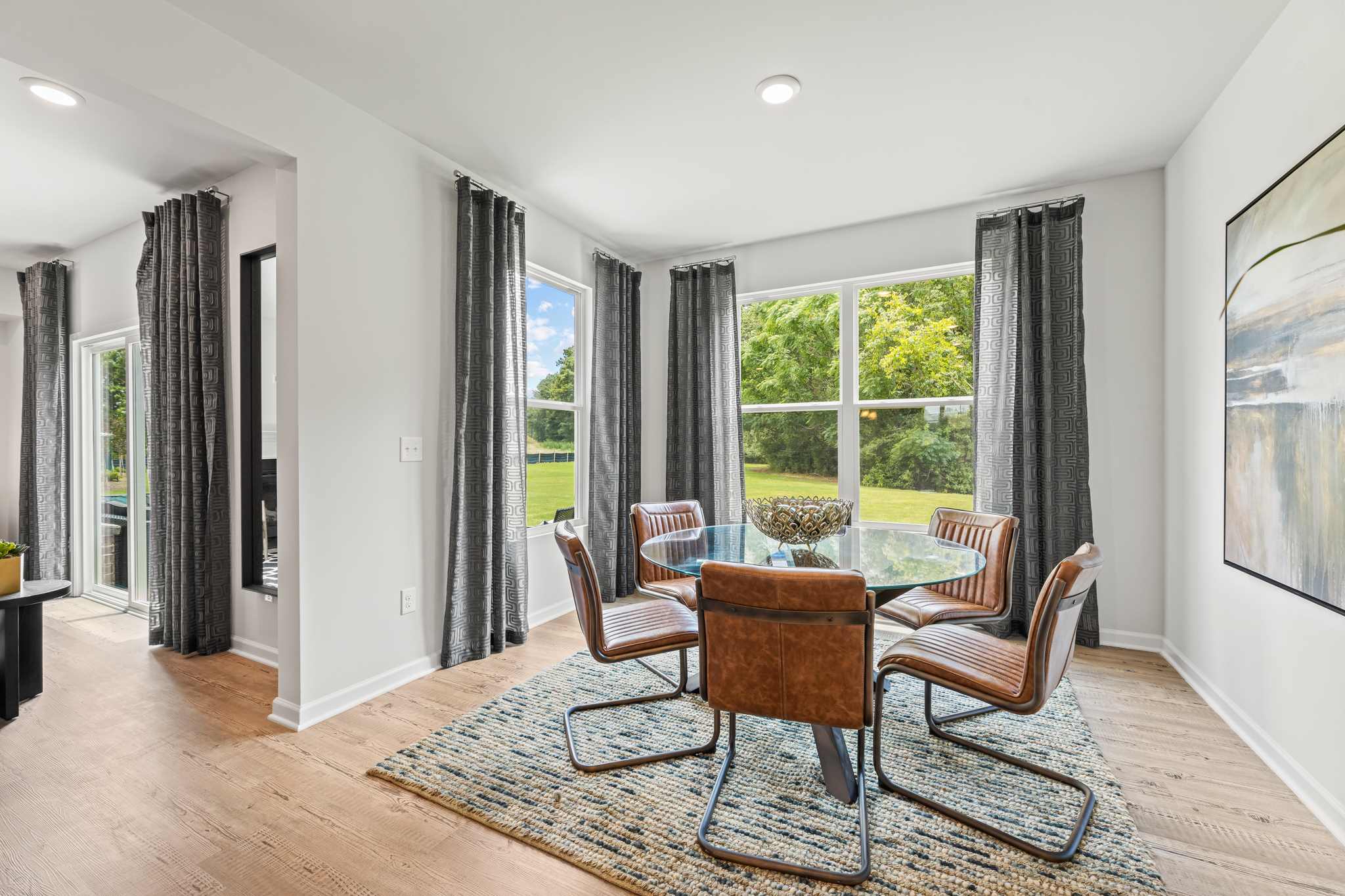 A room with a table chairs and a rug.