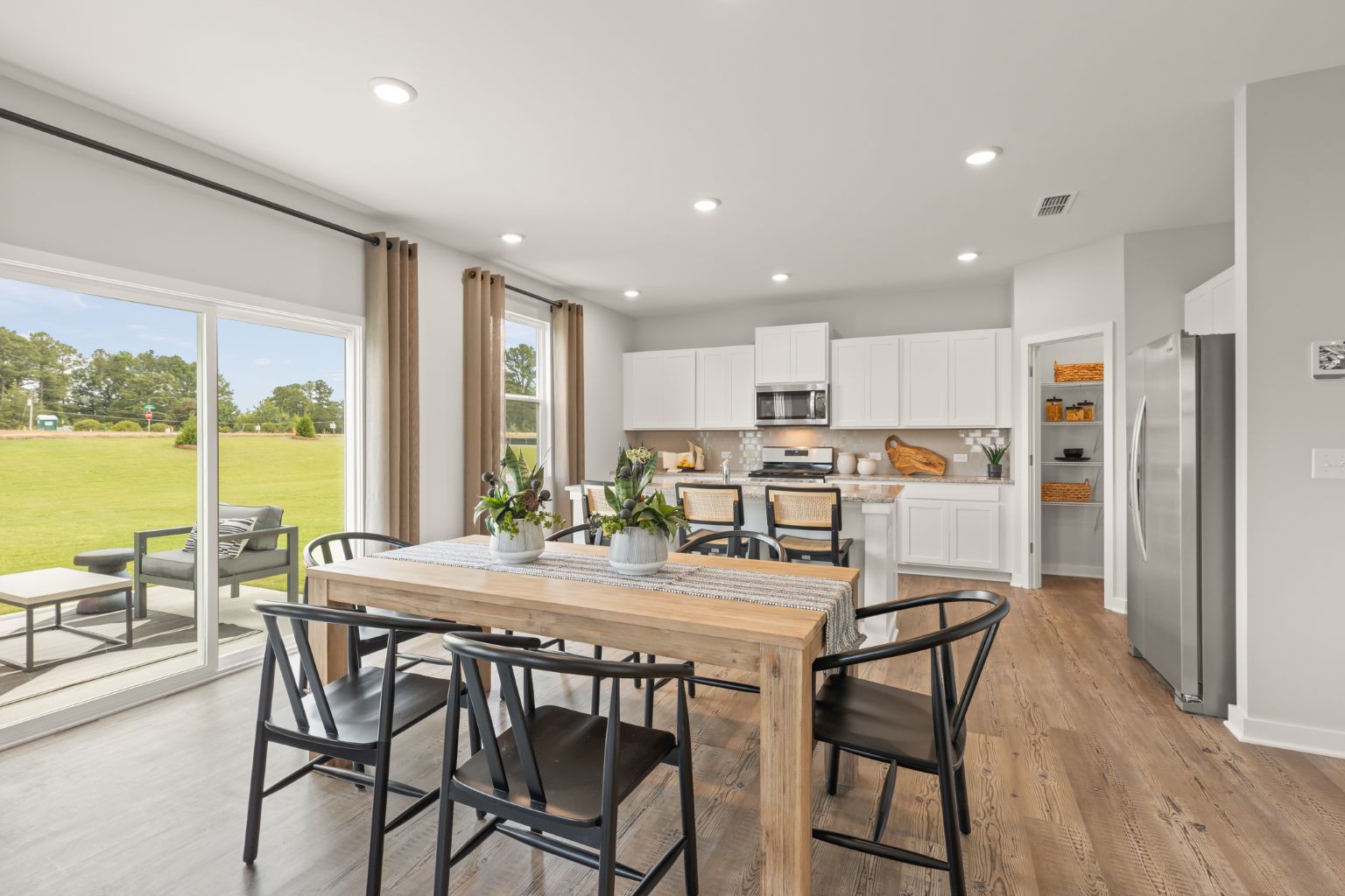 A kitchen with a dining table and chairs.