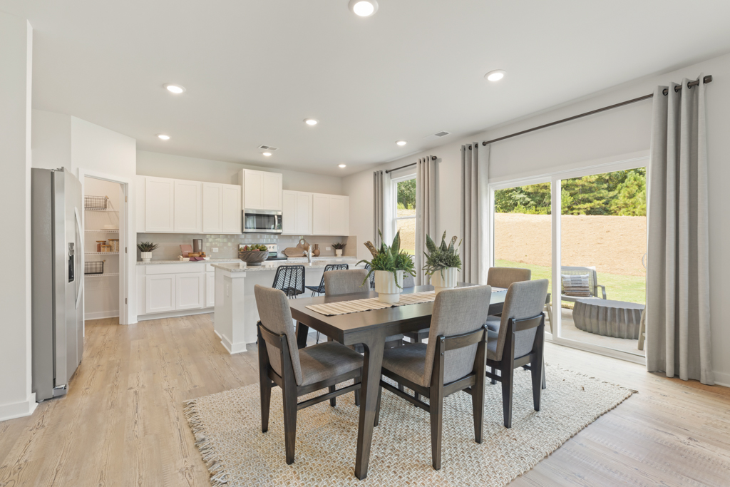 A kitchen with a dining table and chairs.