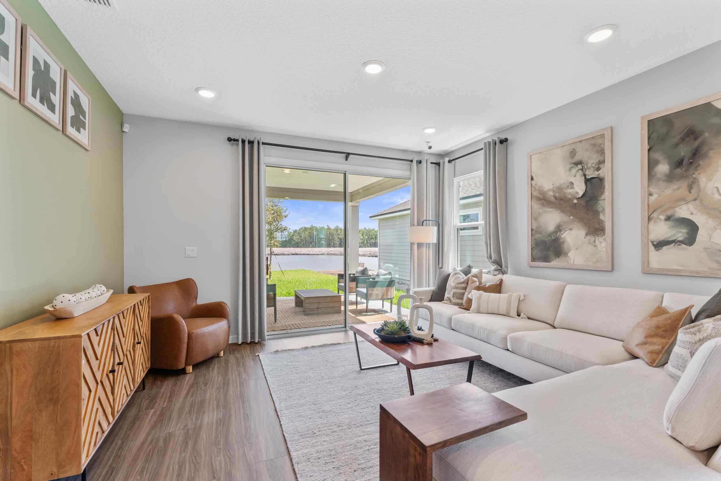 Silverbell II Model Home Living Room with Large Couch and Patio Doors at Camden Woods in Kingsland, GA