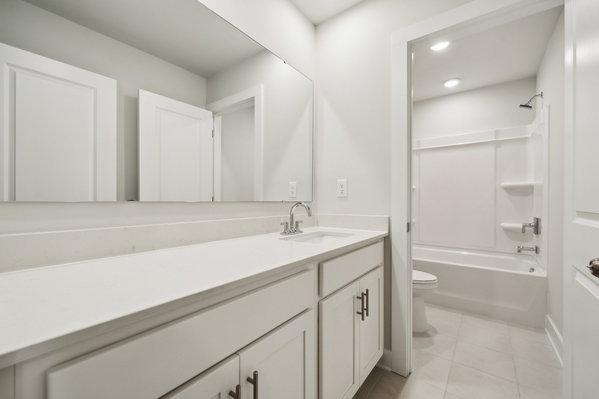 A bathroom with white cabinets.