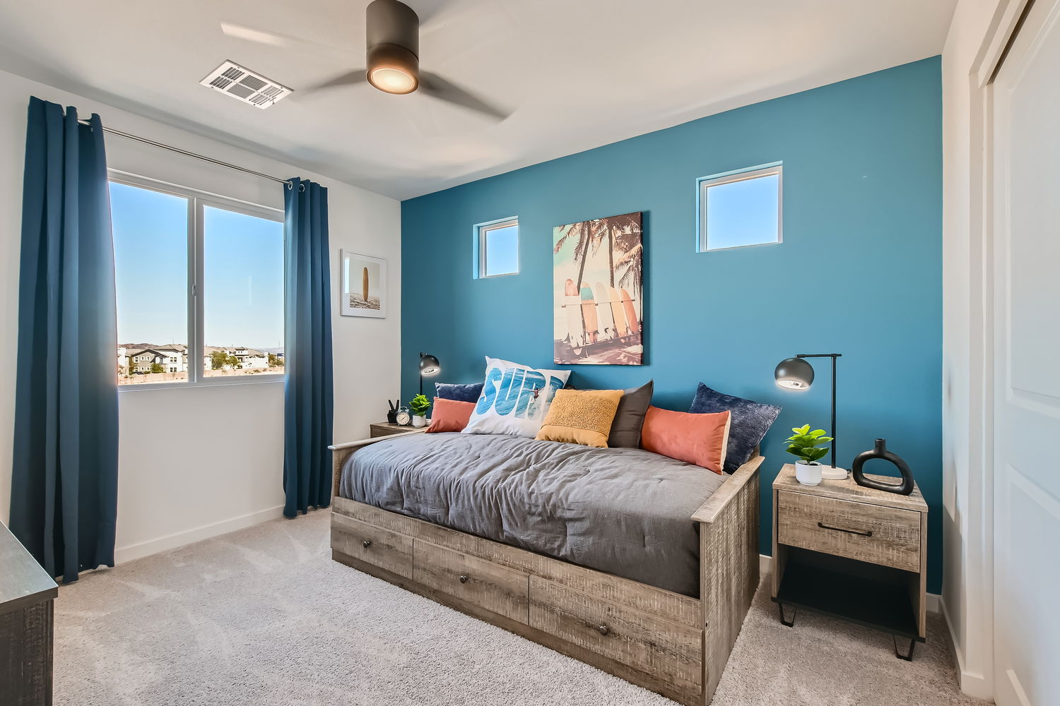 A bedroom with a bed and a blue wall.
