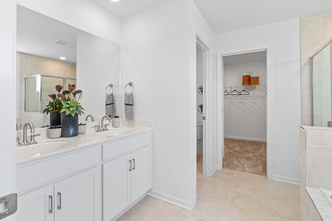 A bathroom with white cabinets.