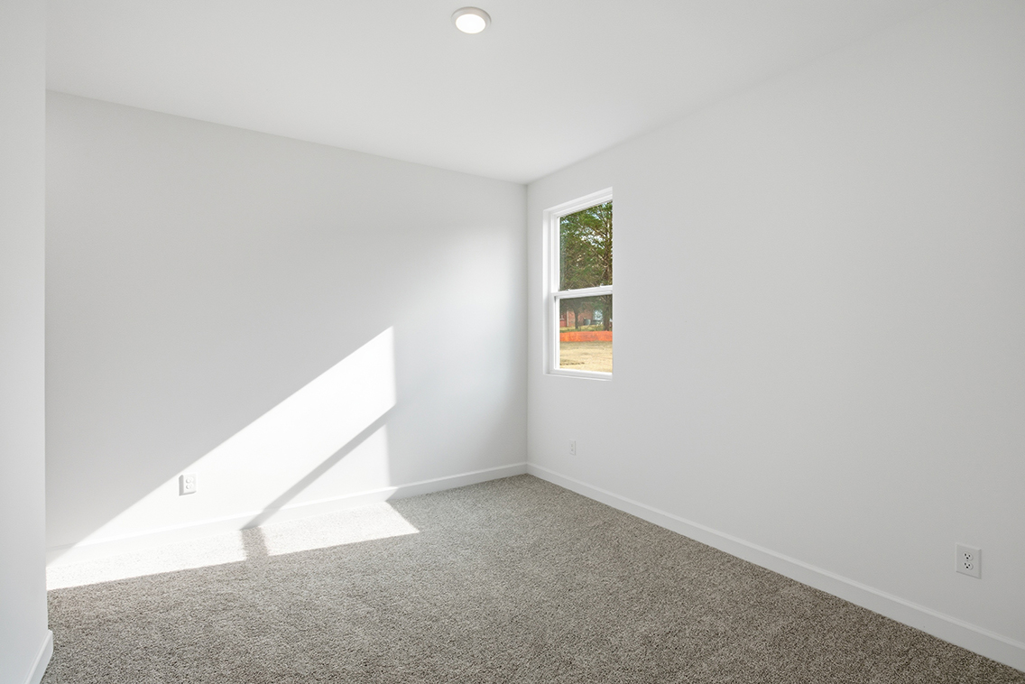 A room with a window and a carpet.