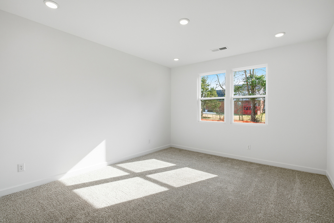 A room with a window and a rug in it.