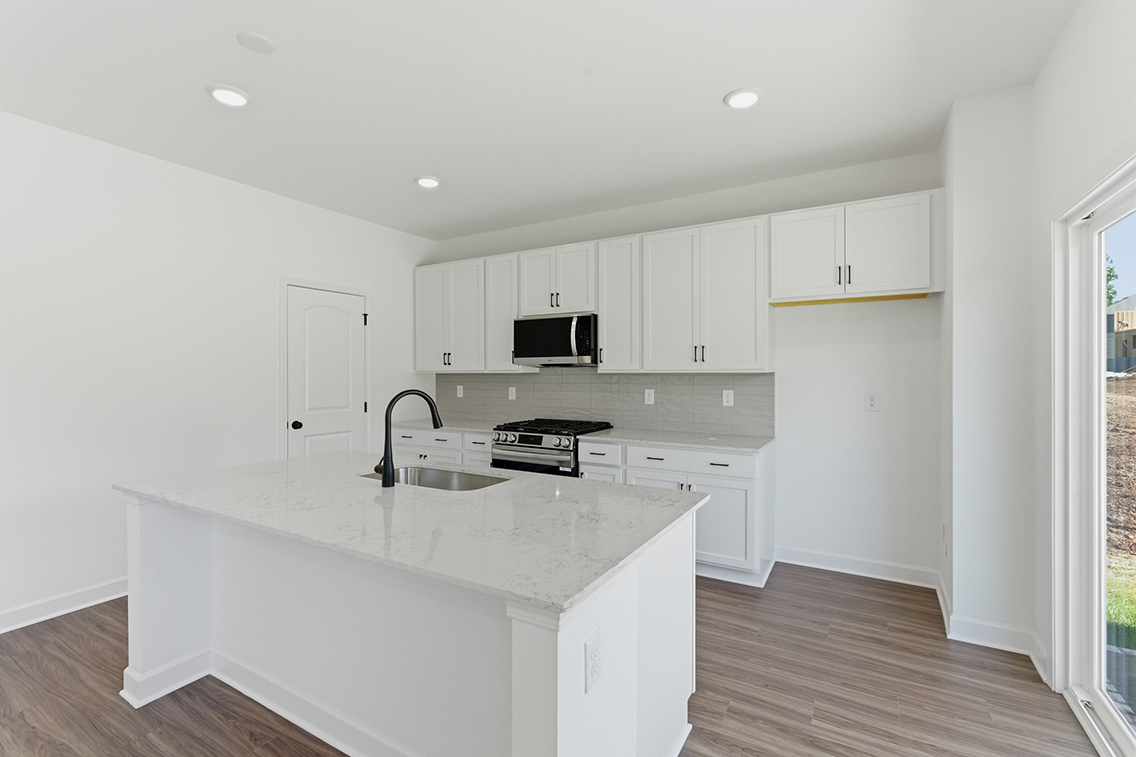 A kitchen with white cabinets.