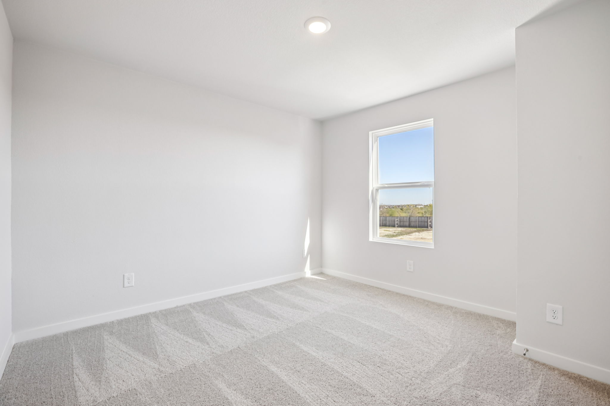 A room with a window and a carpet.