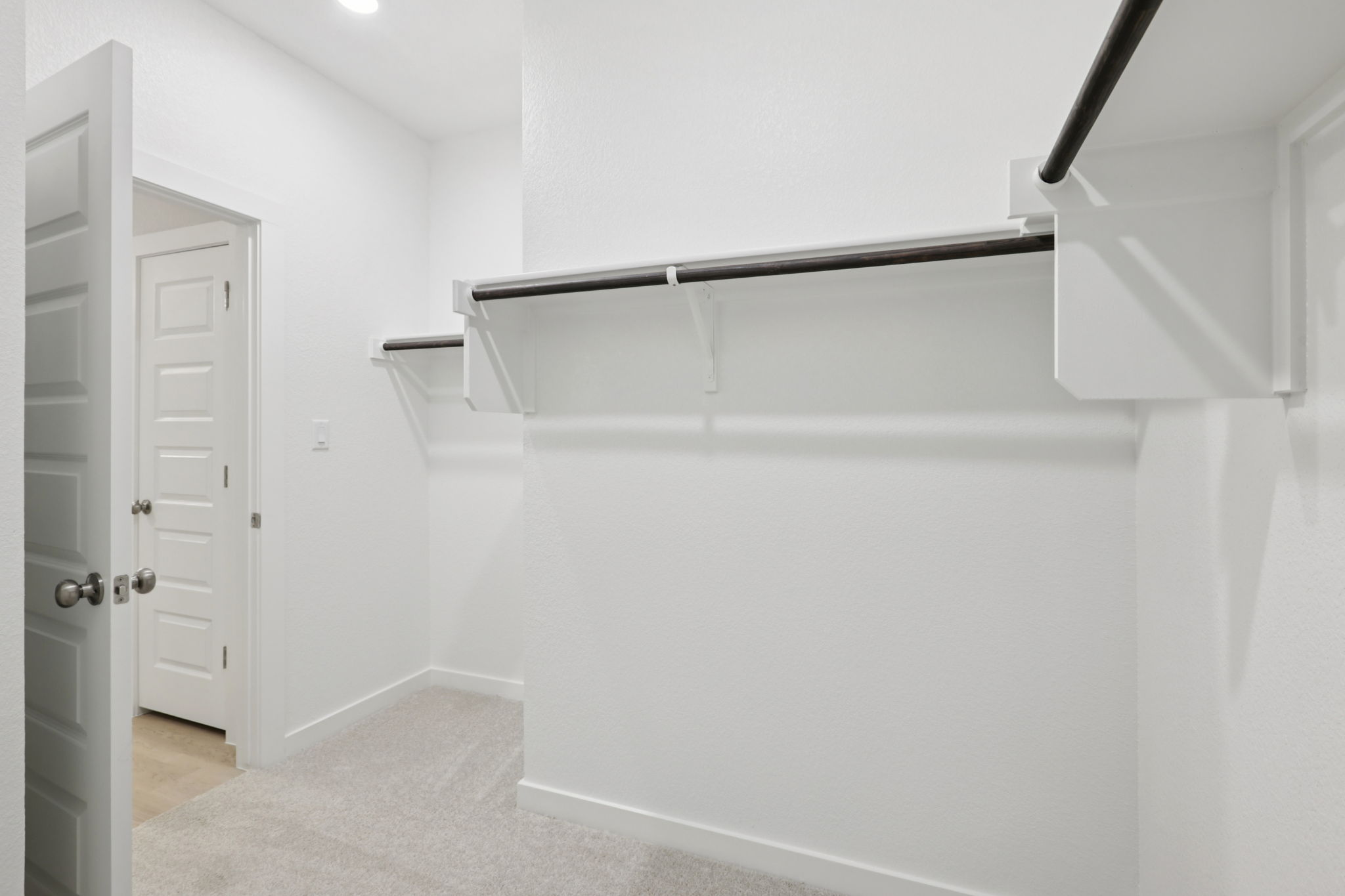 A white wall with a metal bar.