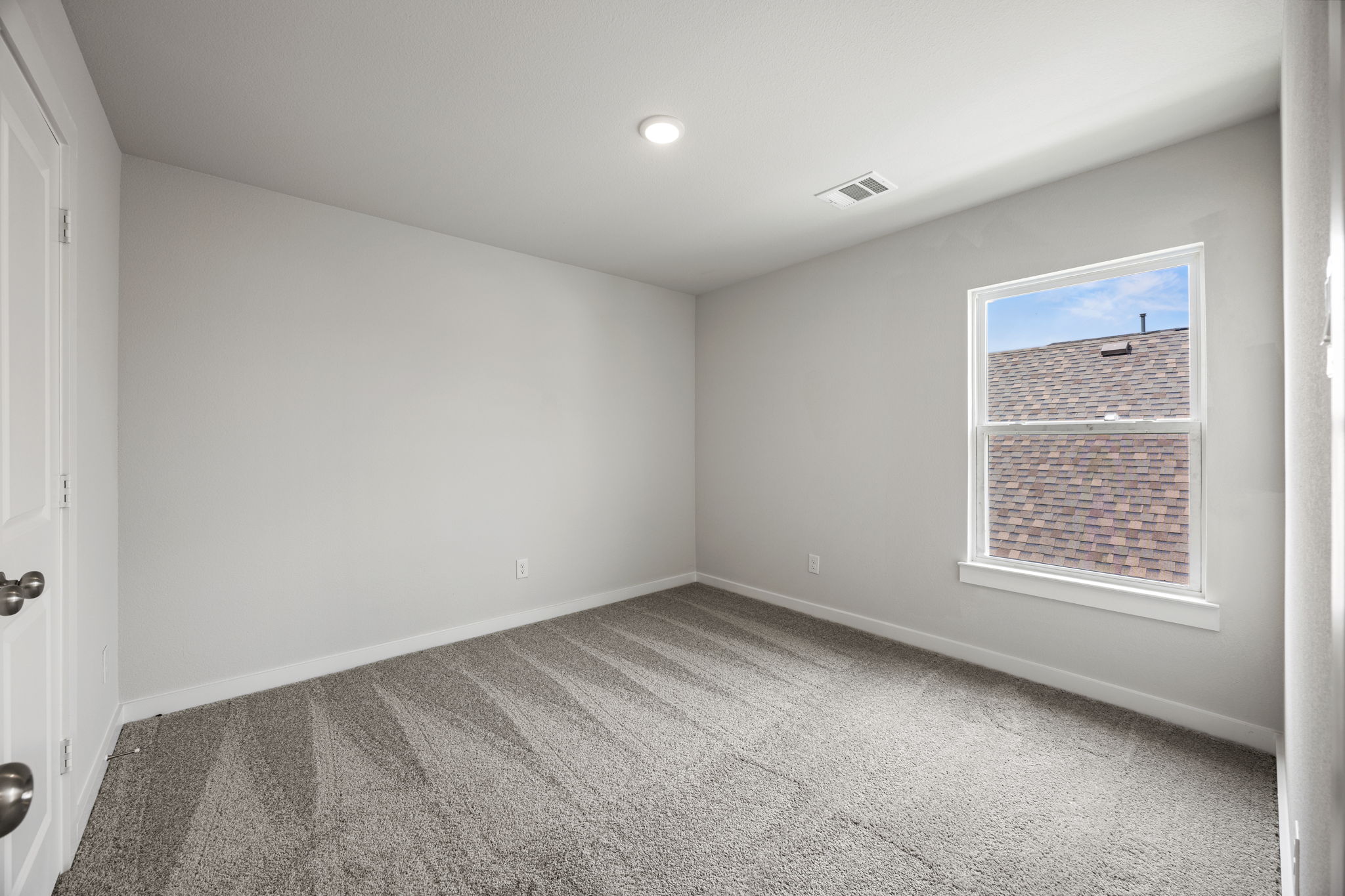 A room with a window and a carpet.