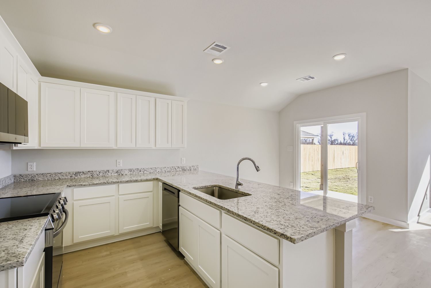 A kitchen with white cabinets.
