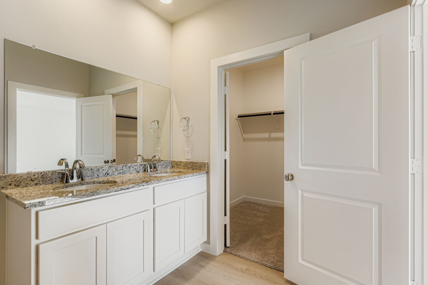 A bathroom with white cabinets.
