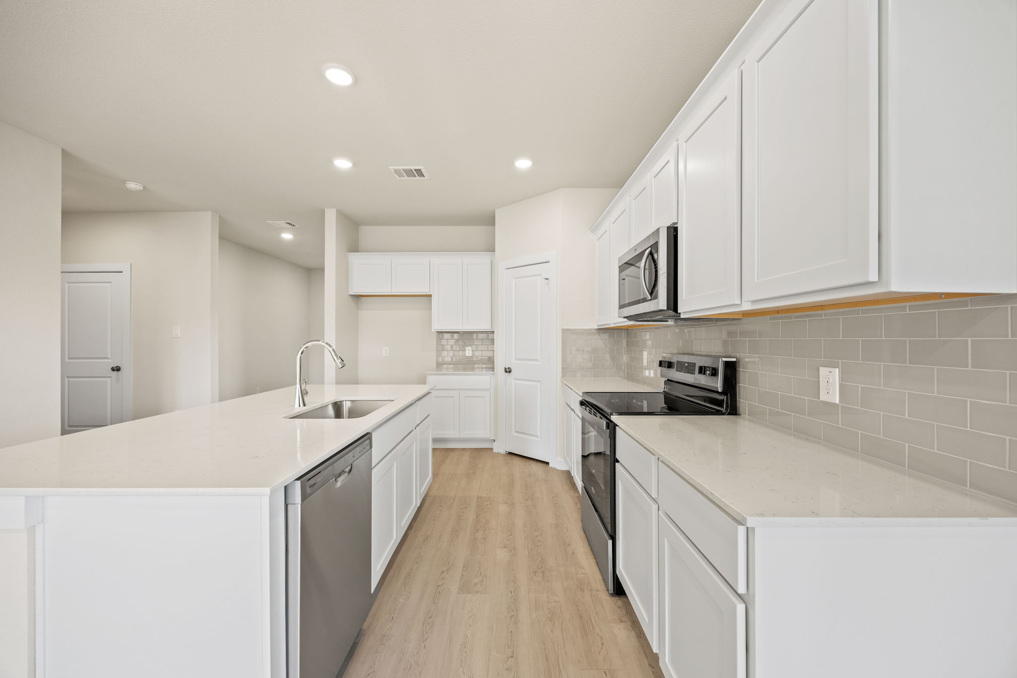 A kitchen with white cabinets.
