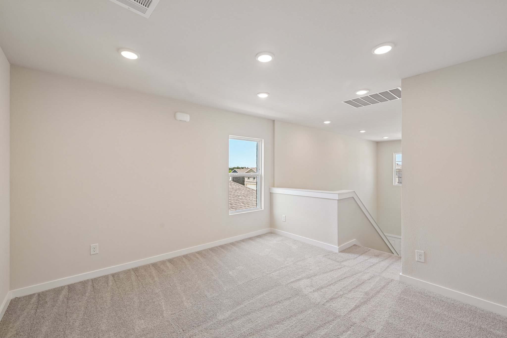 A room with a carpet and a window.