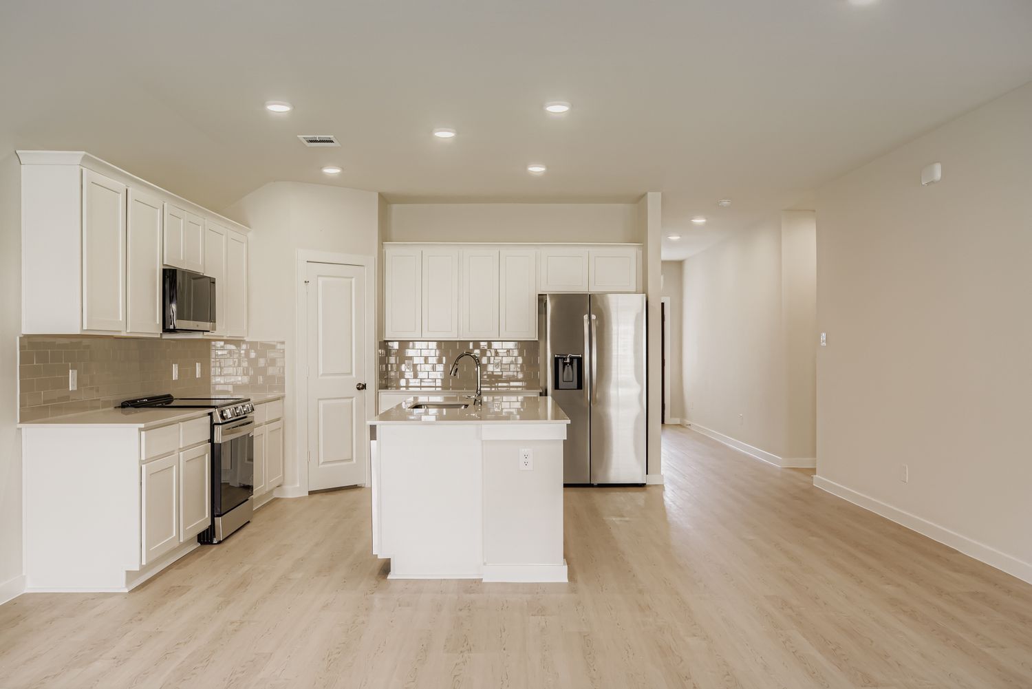A kitchen with white cabinets.