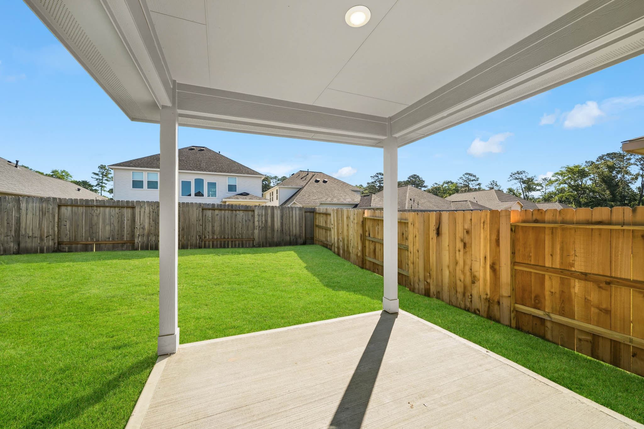 A fenced in yard with a house in the background.