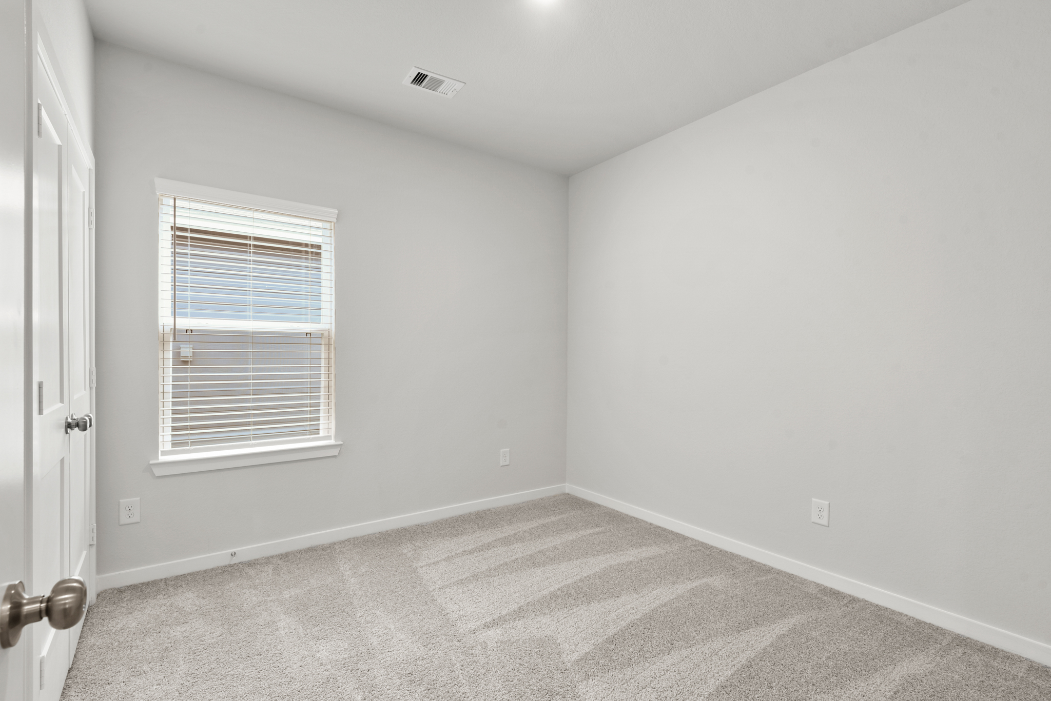 A room with a carpet and a window.