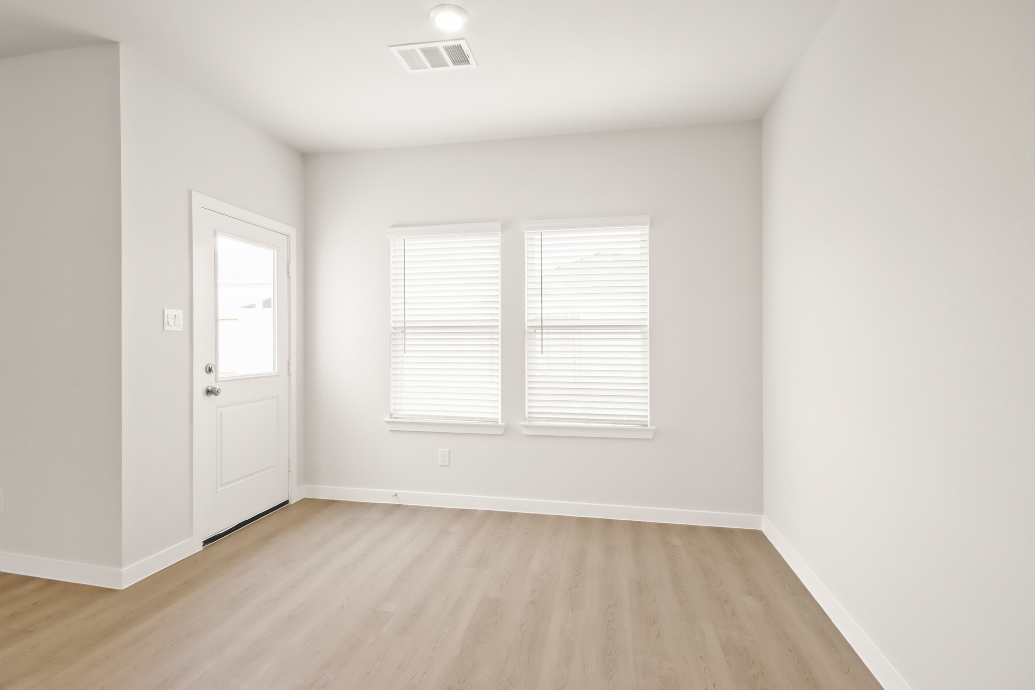 A room with white walls and a wood floor.