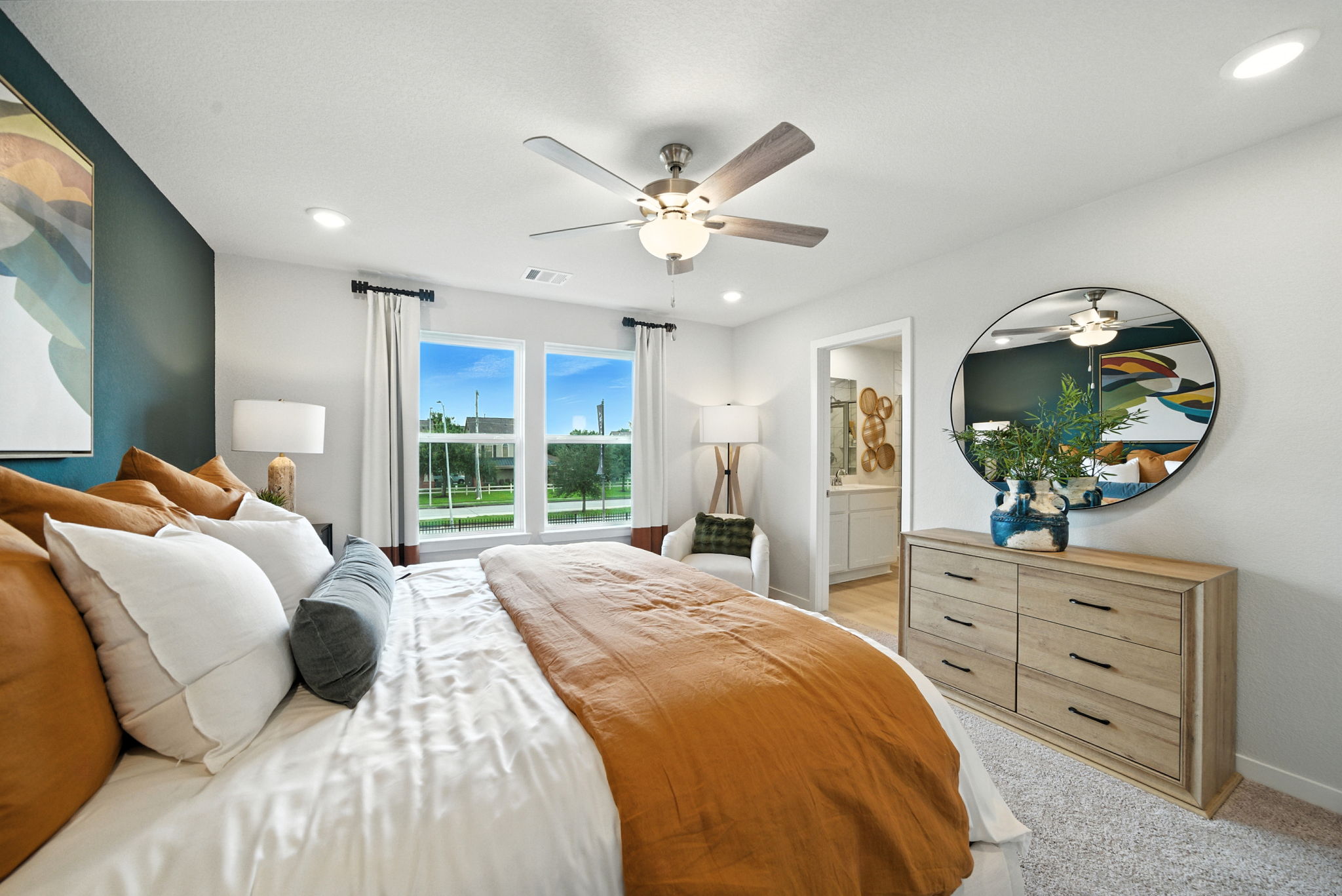 A bedroom with a large mirror.