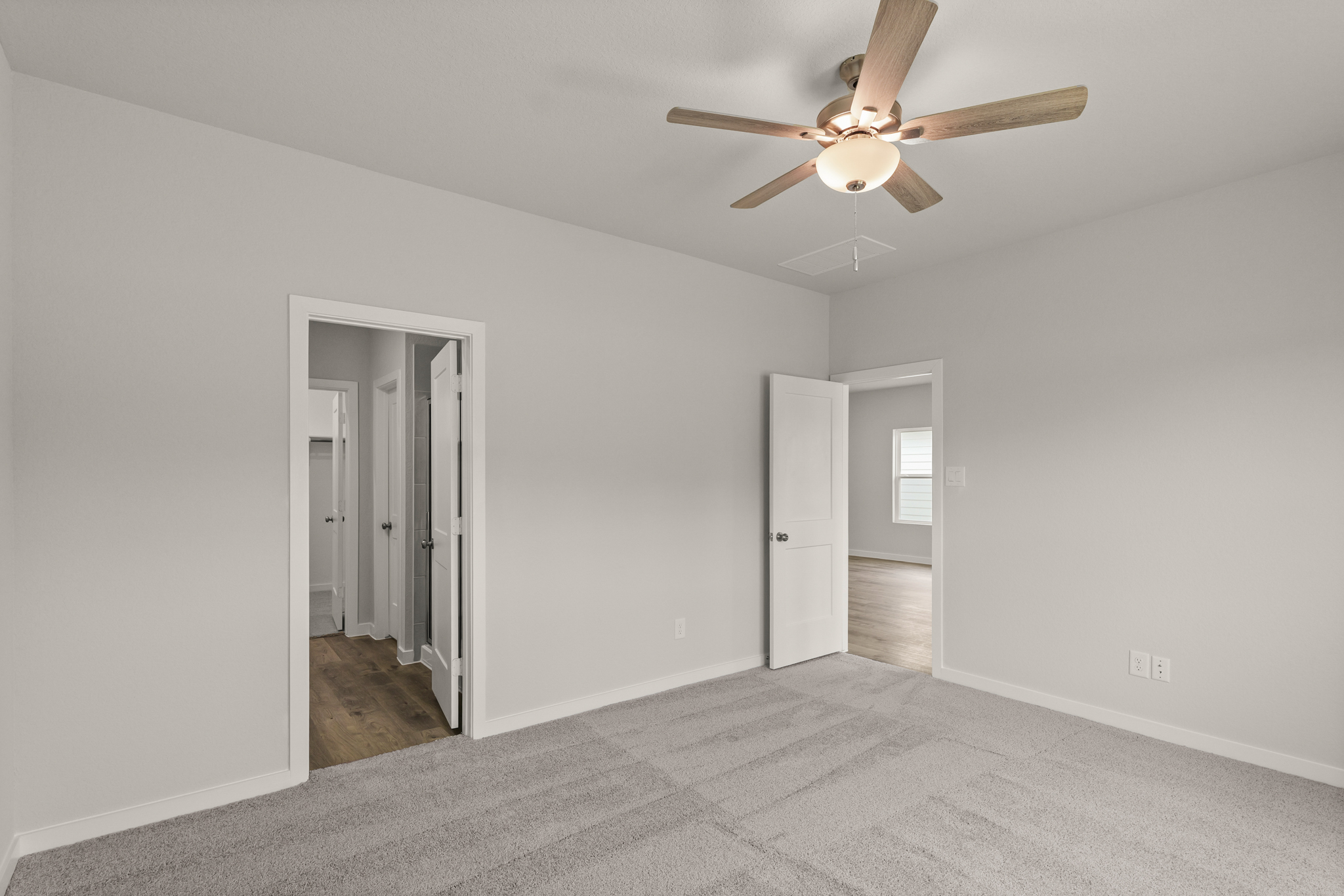 A room with a ceiling fan and a door.