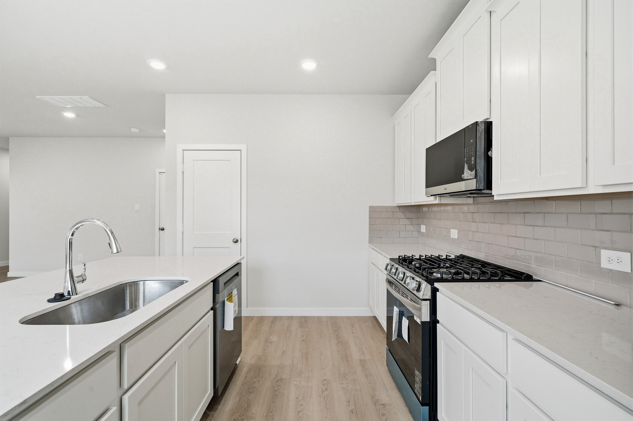 A kitchen with white cabinets.