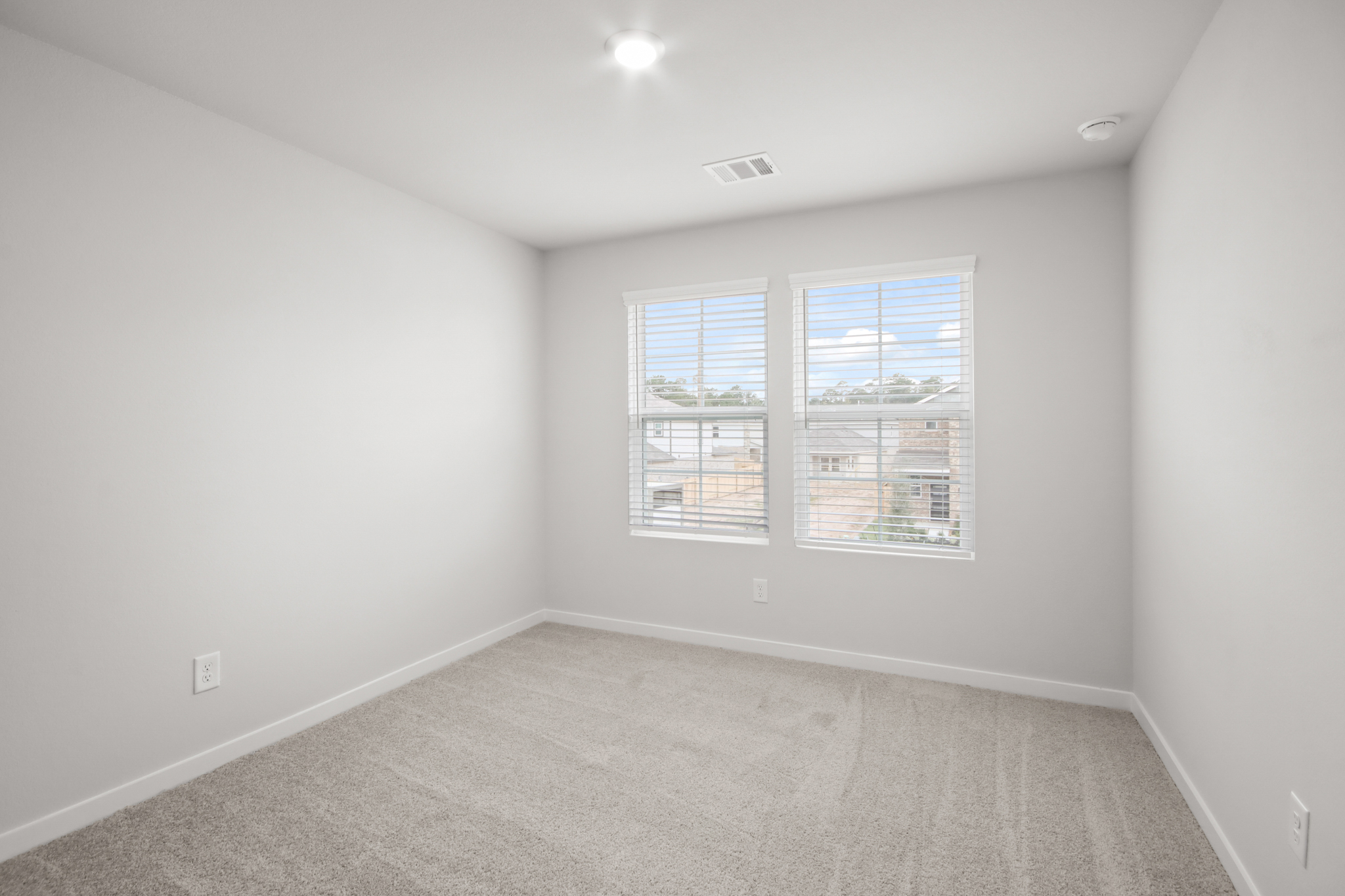 A room with a window and a carpet.