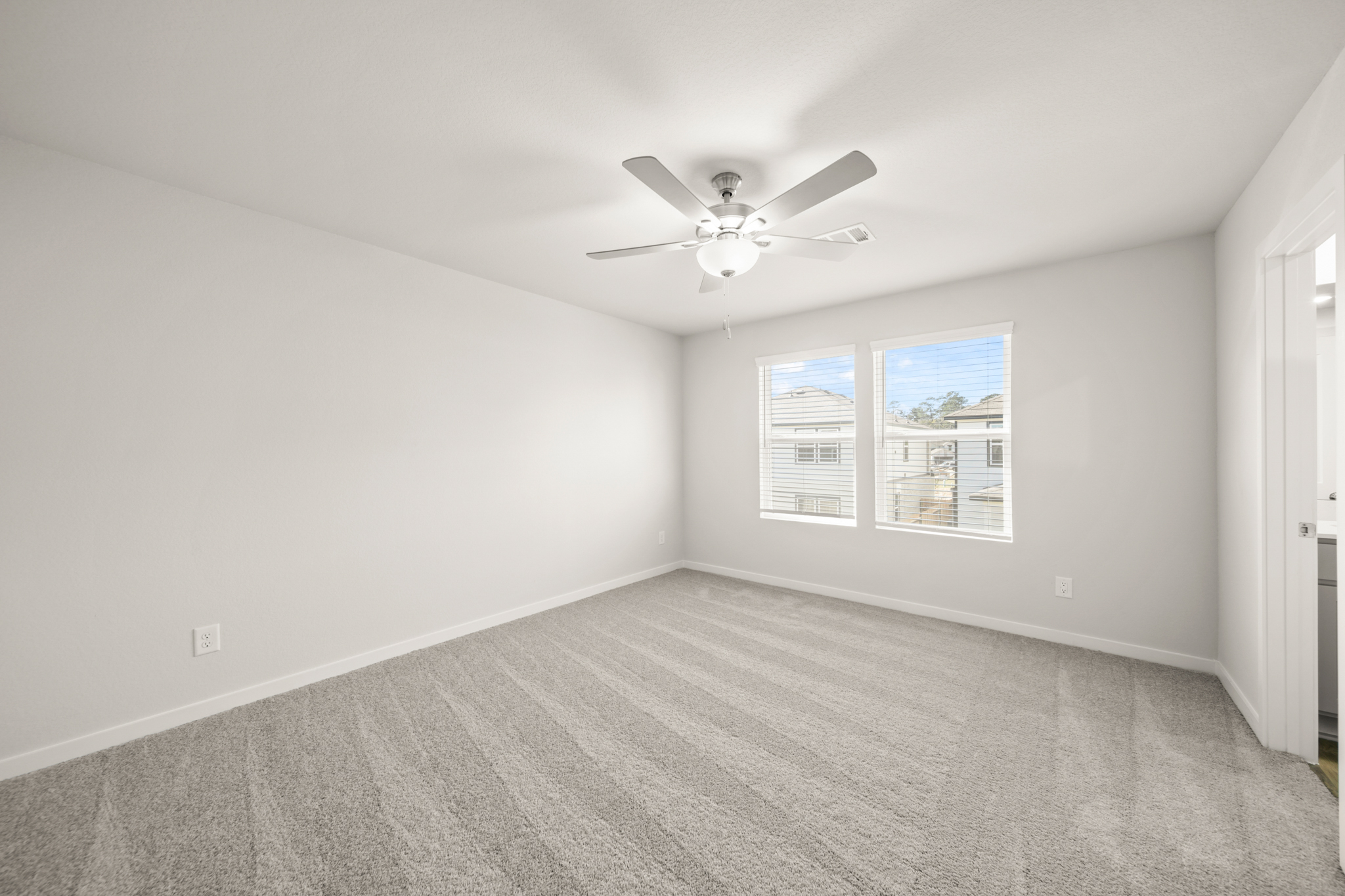 A room with a ceiling fan and a window.