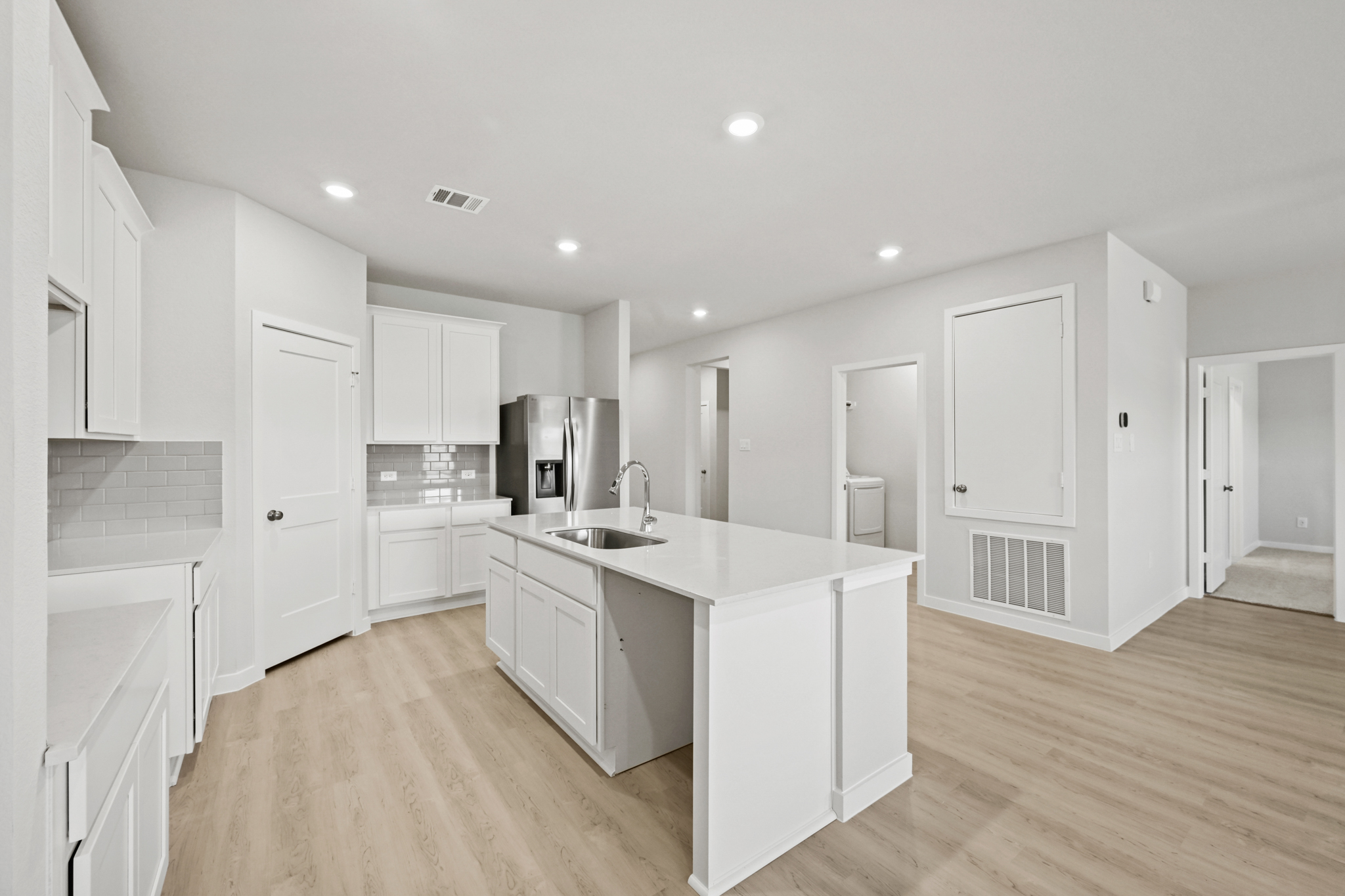 A kitchen with white cabinets.