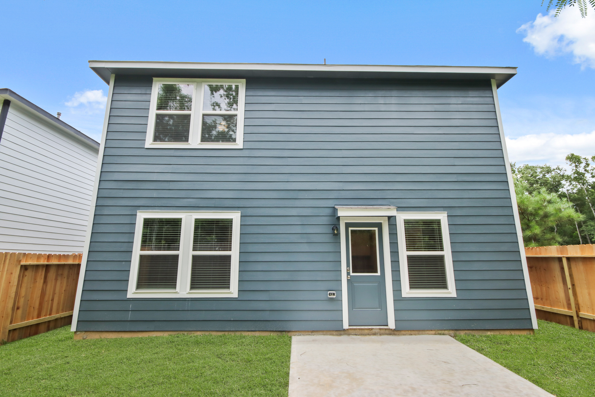 A grey house with a white door.