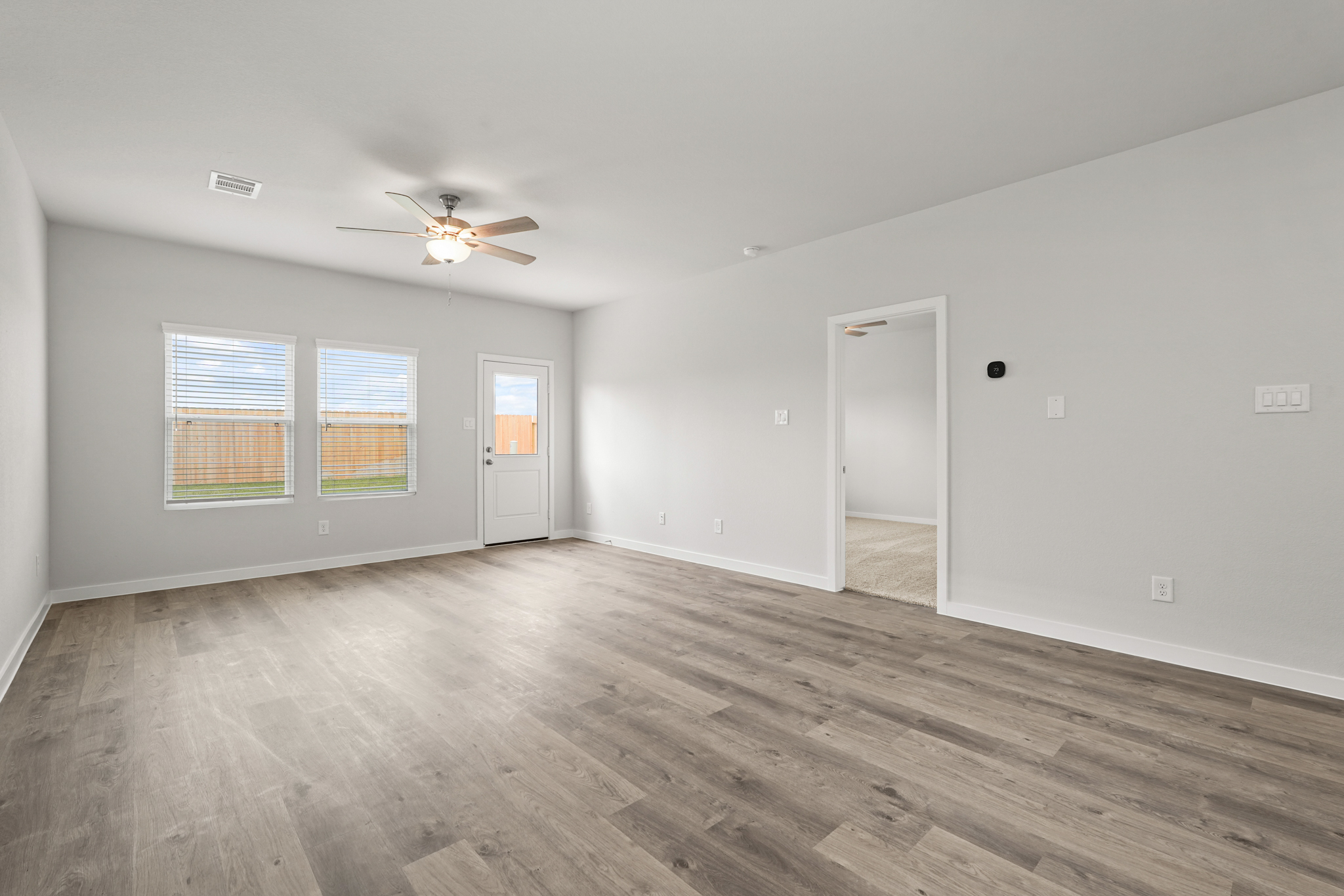 A room with a wood floor and a ceiling fan.