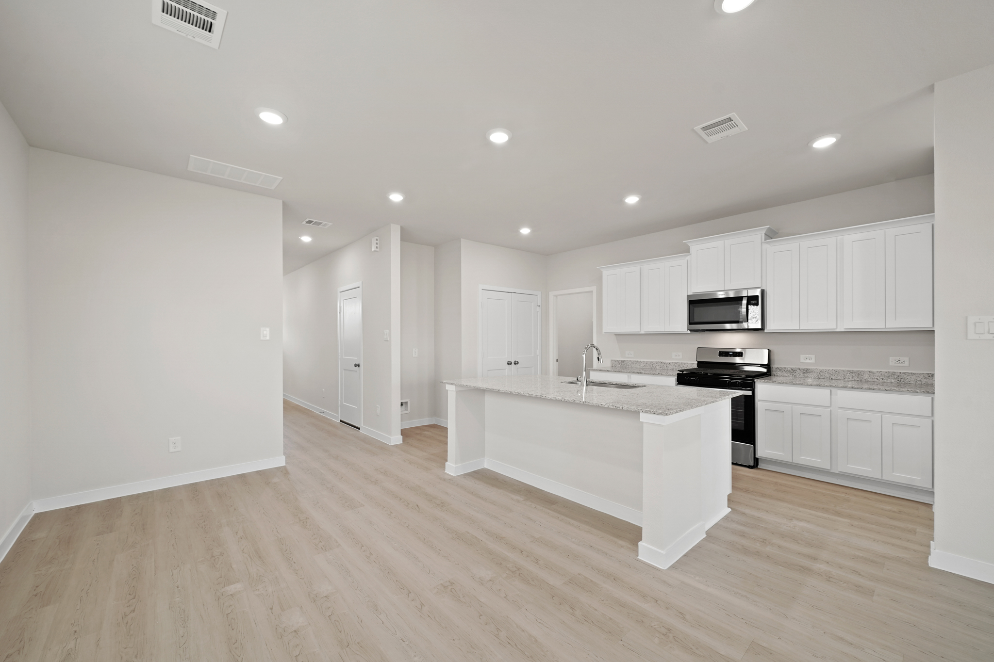 A kitchen with white cabinets.