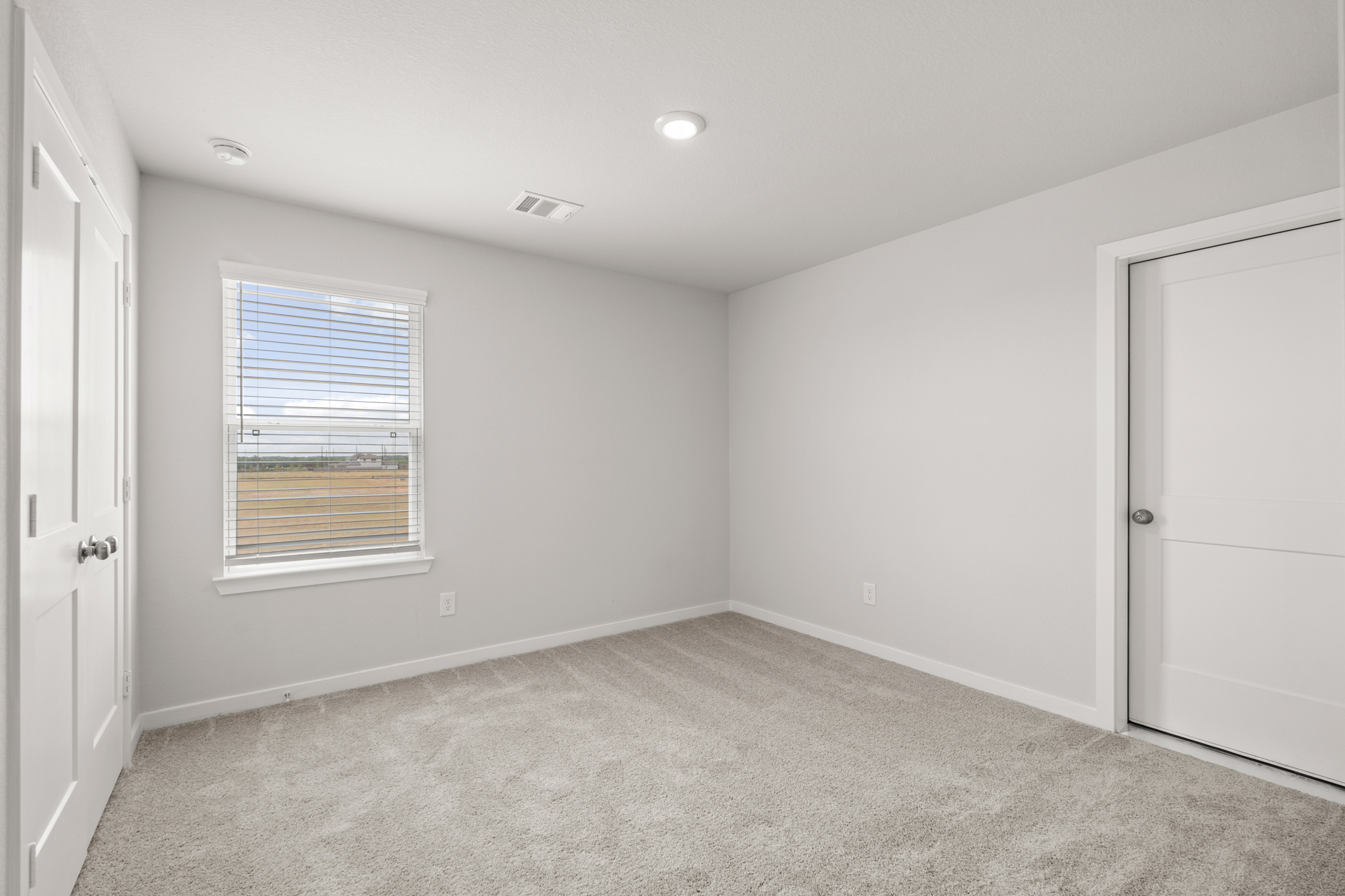 A room with a carpet and a window.