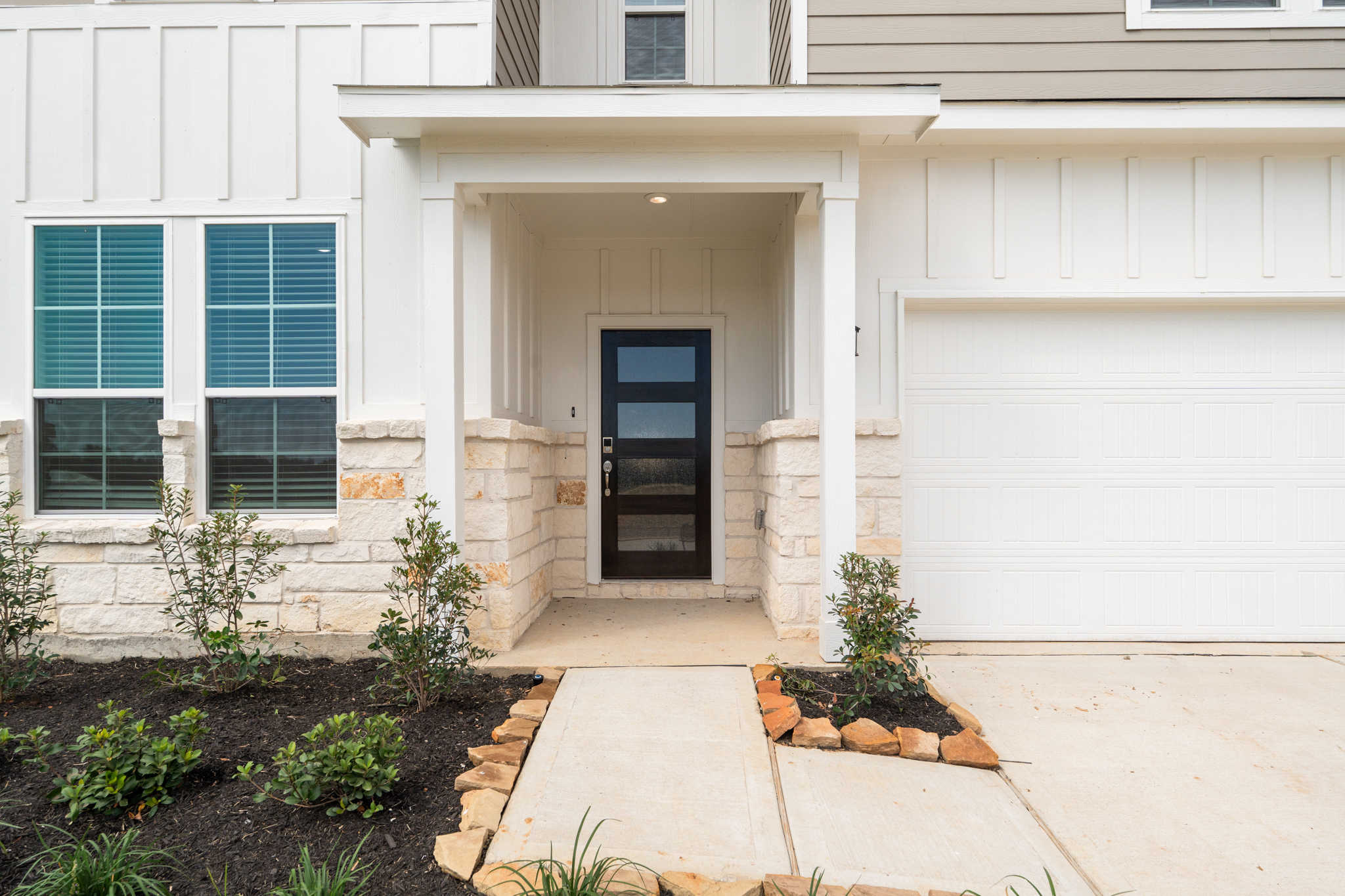A garage door and a white house.