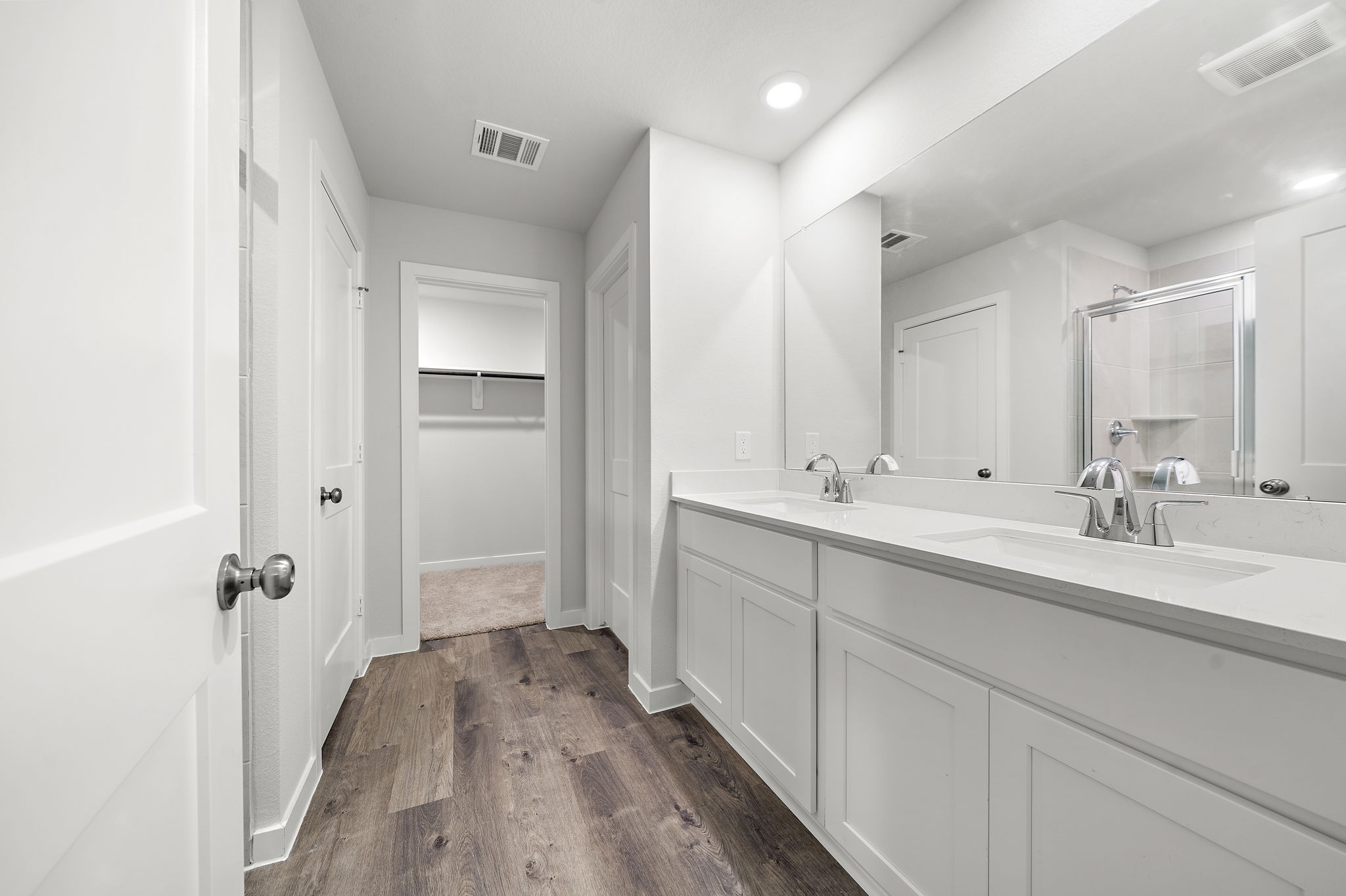 A bathroom with white cabinets.