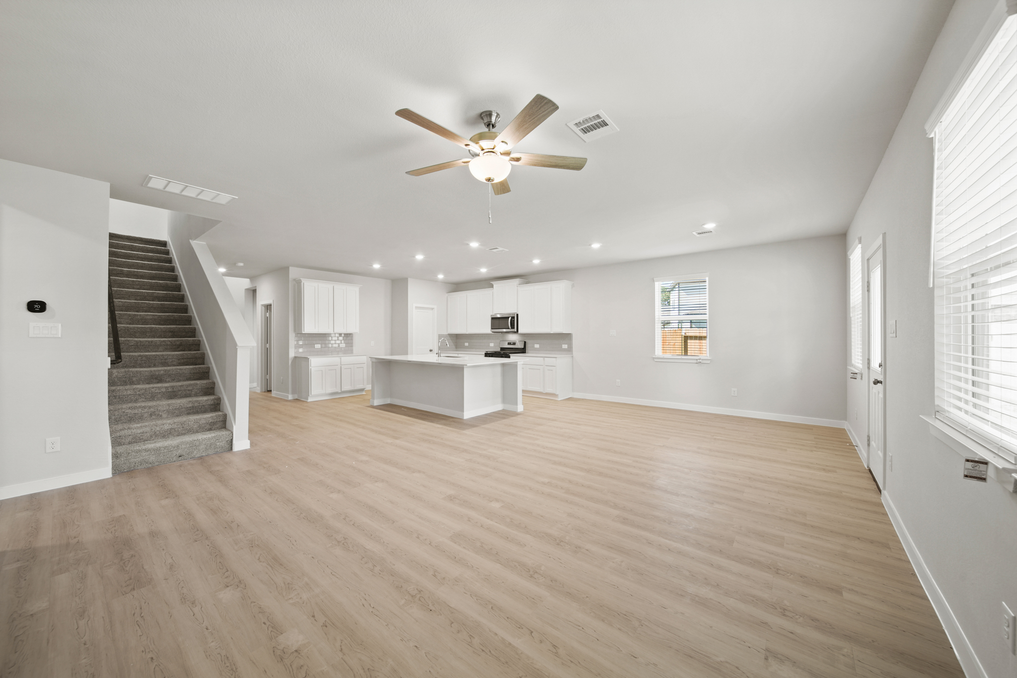 A large empty room with a wood floor and a wood floor.