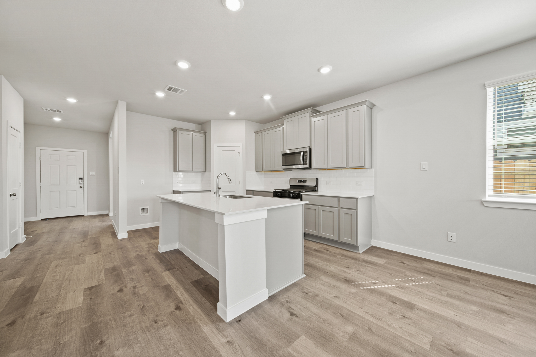 A kitchen with white cabinets.