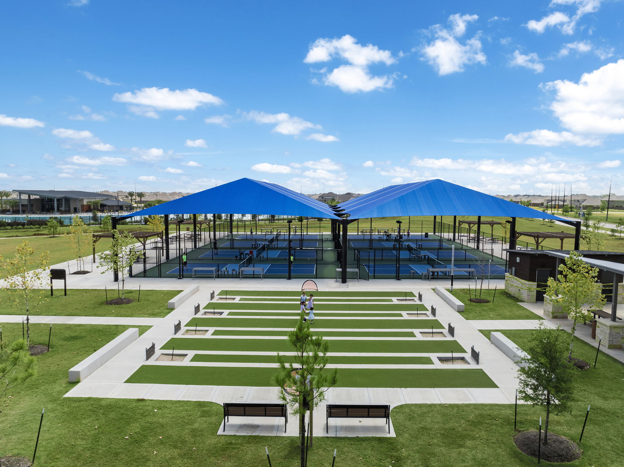 A large green field with a building in the background.