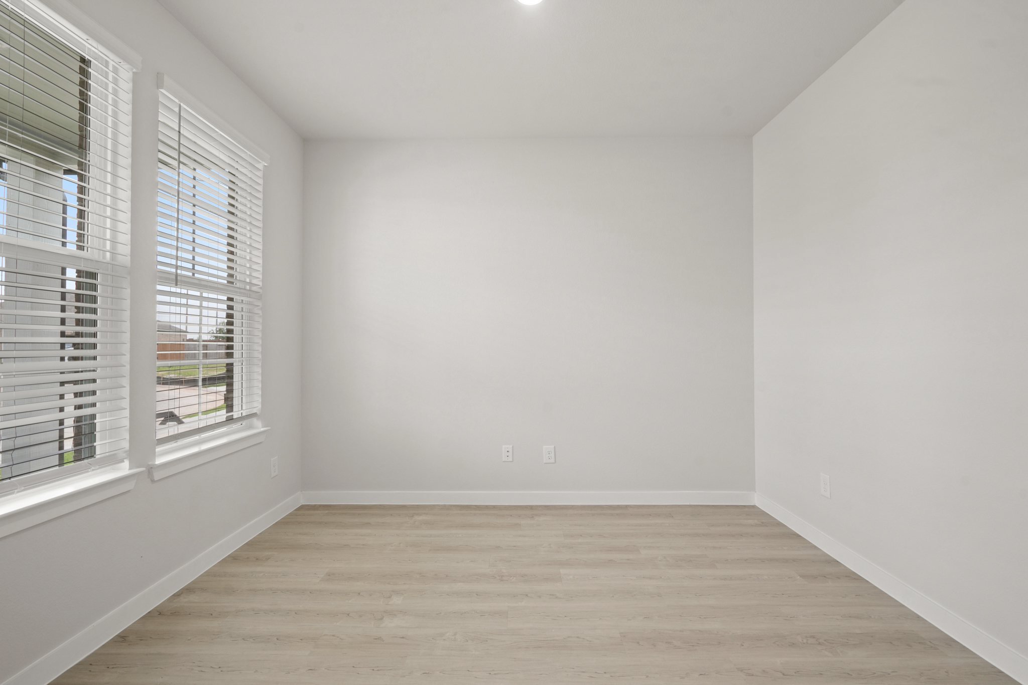 A room with a wood floor and windows.
