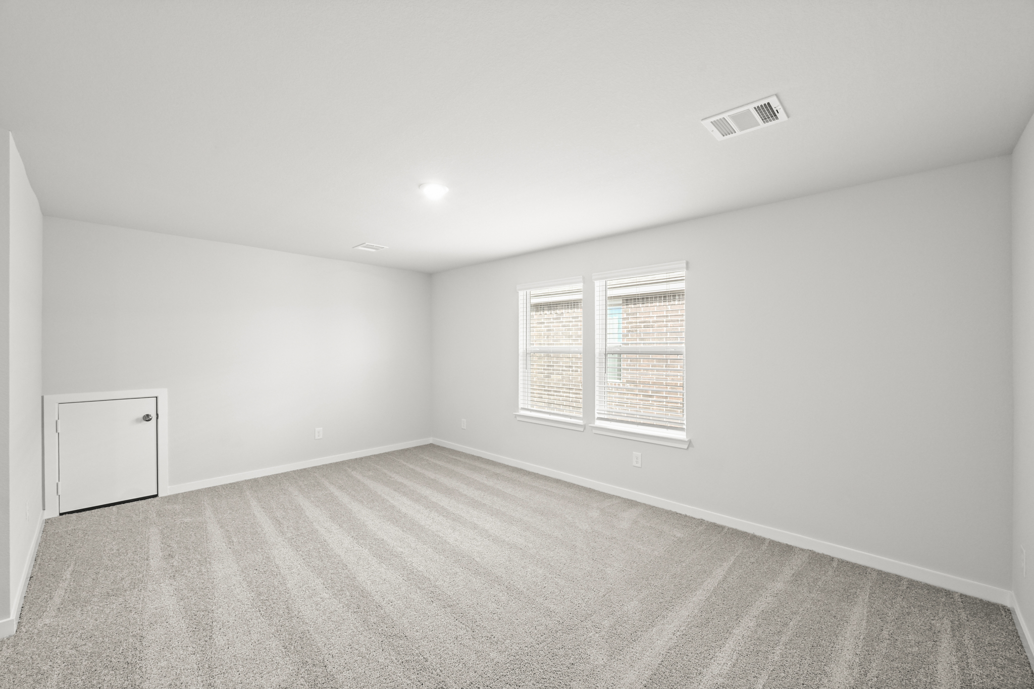 A room with a carpet and a white wall.